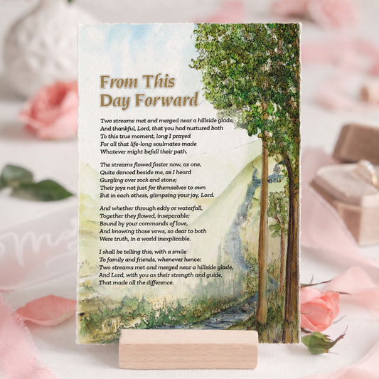 A printed memorial or prayer card with a scenic forest stream illustration and the heading 'From This Day Forward,' displayed on a small wooden stand against a soft pink floral background.
